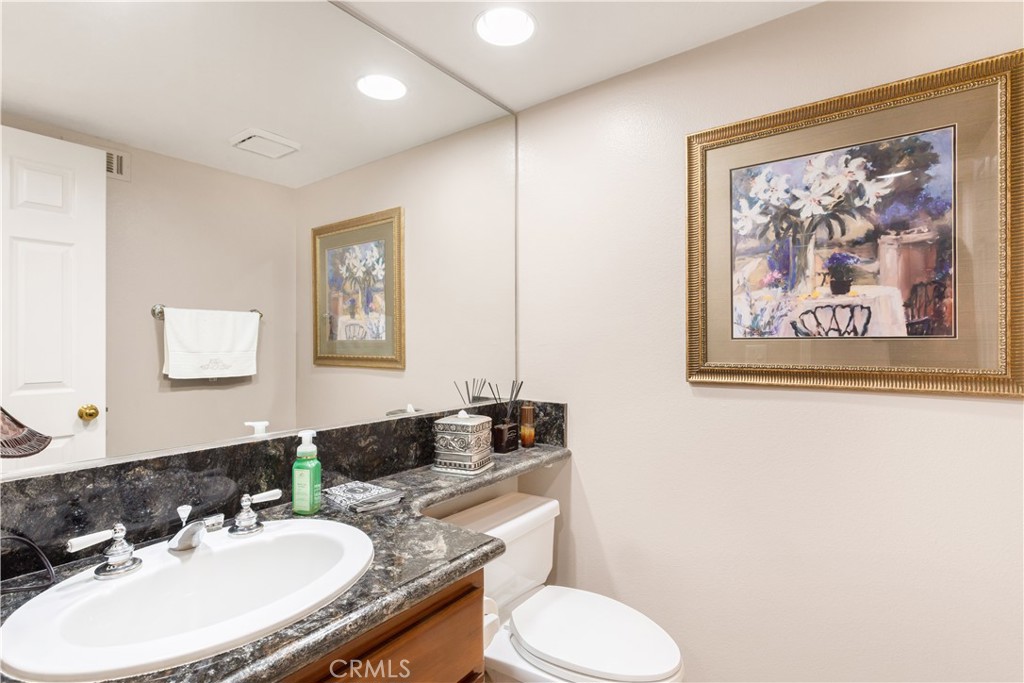 12665 Stanton Avenue Tustin, CA 92782 - Photo 17 of 52 a bathroom with a toilet a sink and mirror