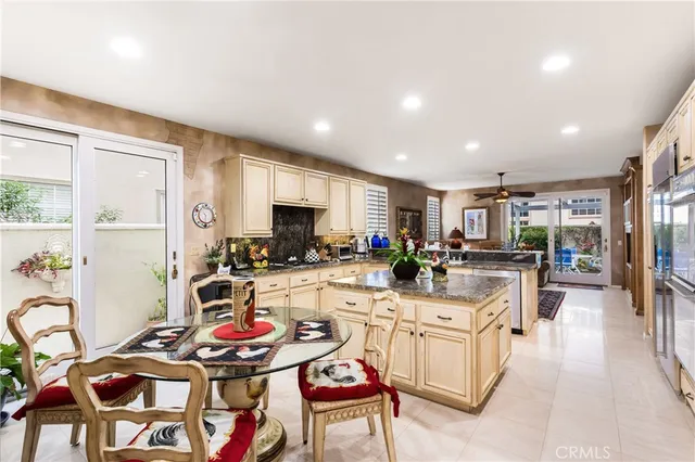 a kitchen with stainless steel appliances kitchen island granite countertop a stove a sink a dining table and chairs with wooden floor