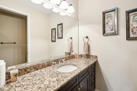 a bathroom with a granite countertop sink and a mirror