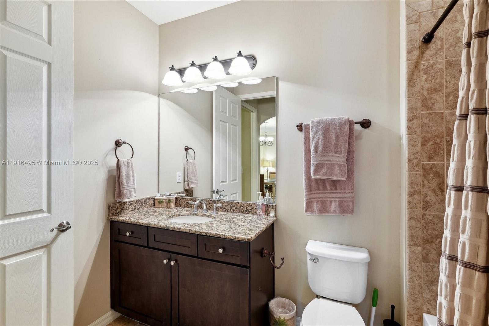 9064 Capistrano Street North, Unit 5004 Naples, FL 34113 - Photo 18 of 27 a bathroom with a toilet sink and mirror