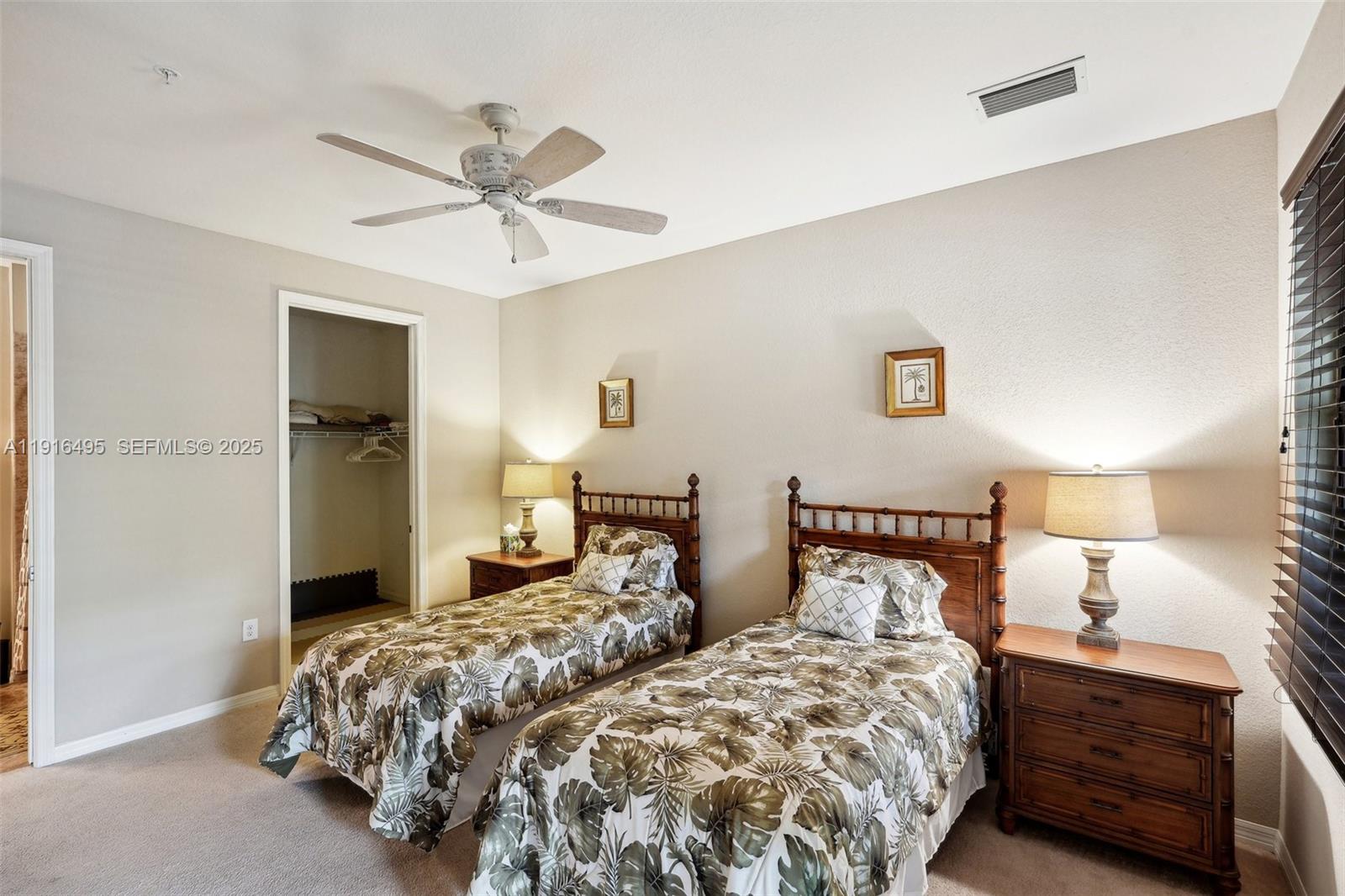 9064 Capistrano Street North, Unit 5004 Naples, FL 34113 - Photo 23 of 27 a bedroom with two beds and a chandelier