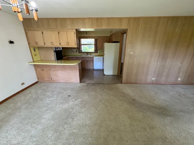 a kitchen with stainless steel appliances kitchen island granite countertop a sink stove and refrigerator
