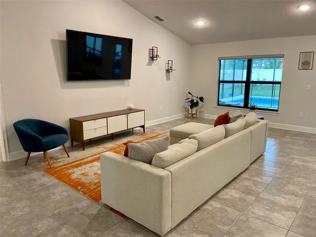 a kitchen with stainless steel appliances a refrigerator a stove a sink cabinets and a dining table