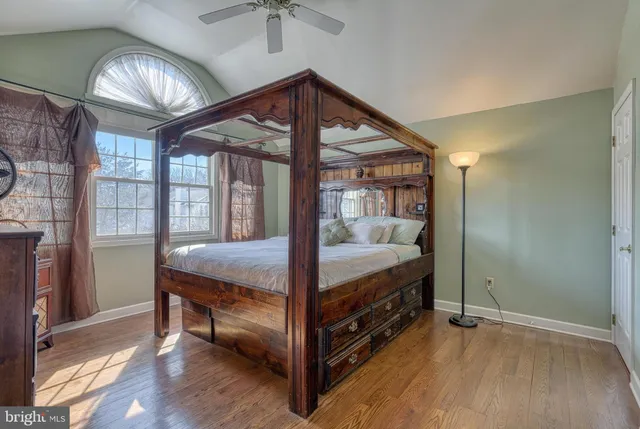 a view of a white house with a big yard and large trees