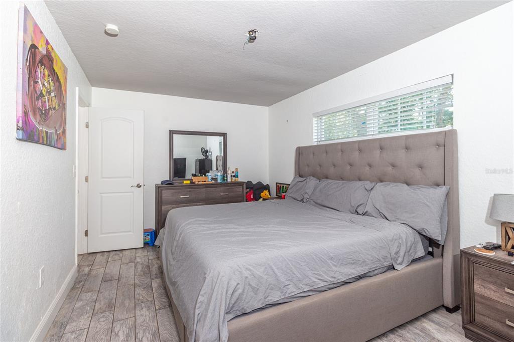 6447 Brandy Drive Spring Hill, FL 34607 - Photo 15 of 25 a bedroom with a large bed and a chandelier