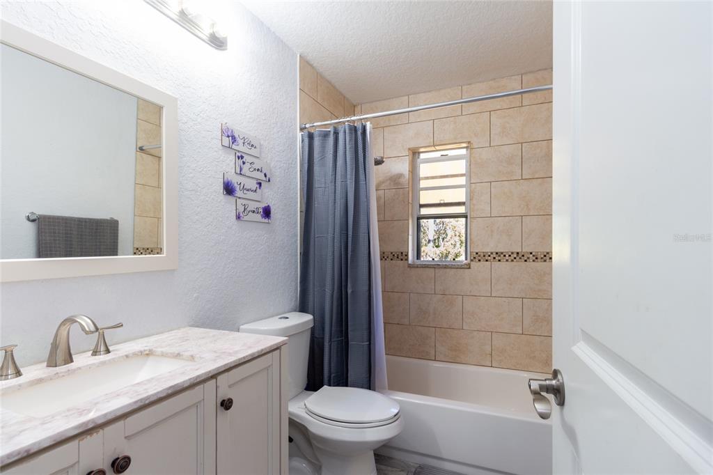 6447 Brandy Drive Spring Hill, FL 34607 - Photo 19 of 25 a bathroom with a granite countertop sink a toilet and shower