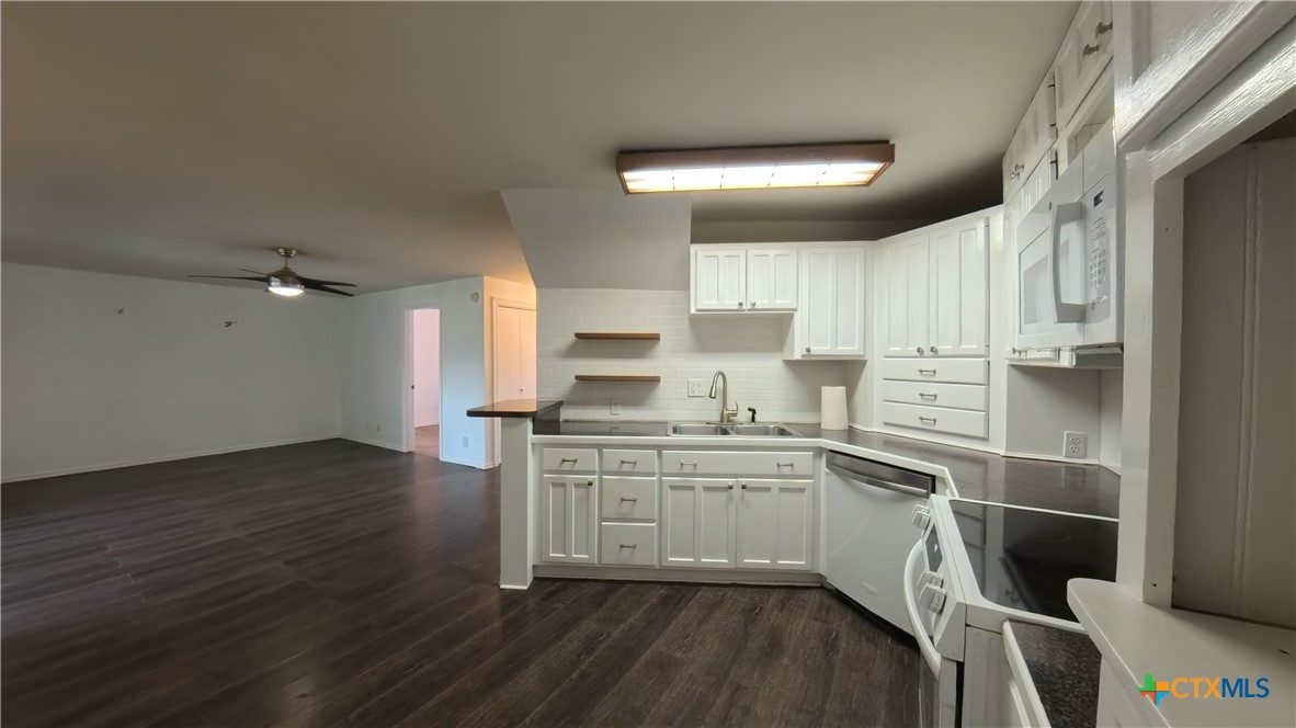 929 Red Bluff Ranch Road Pipe Creek, TX 78063 - Photo 9 of 39 a kitchen with wooden floors and appliances