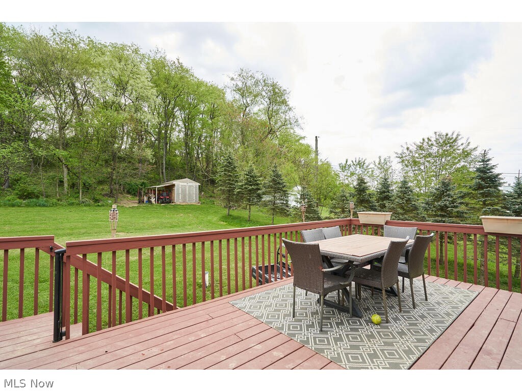 5763 Ruslin Hills Road Dover, OH 44622 - Photo 12 of 17 Wooden deck with a storage unit and a yard