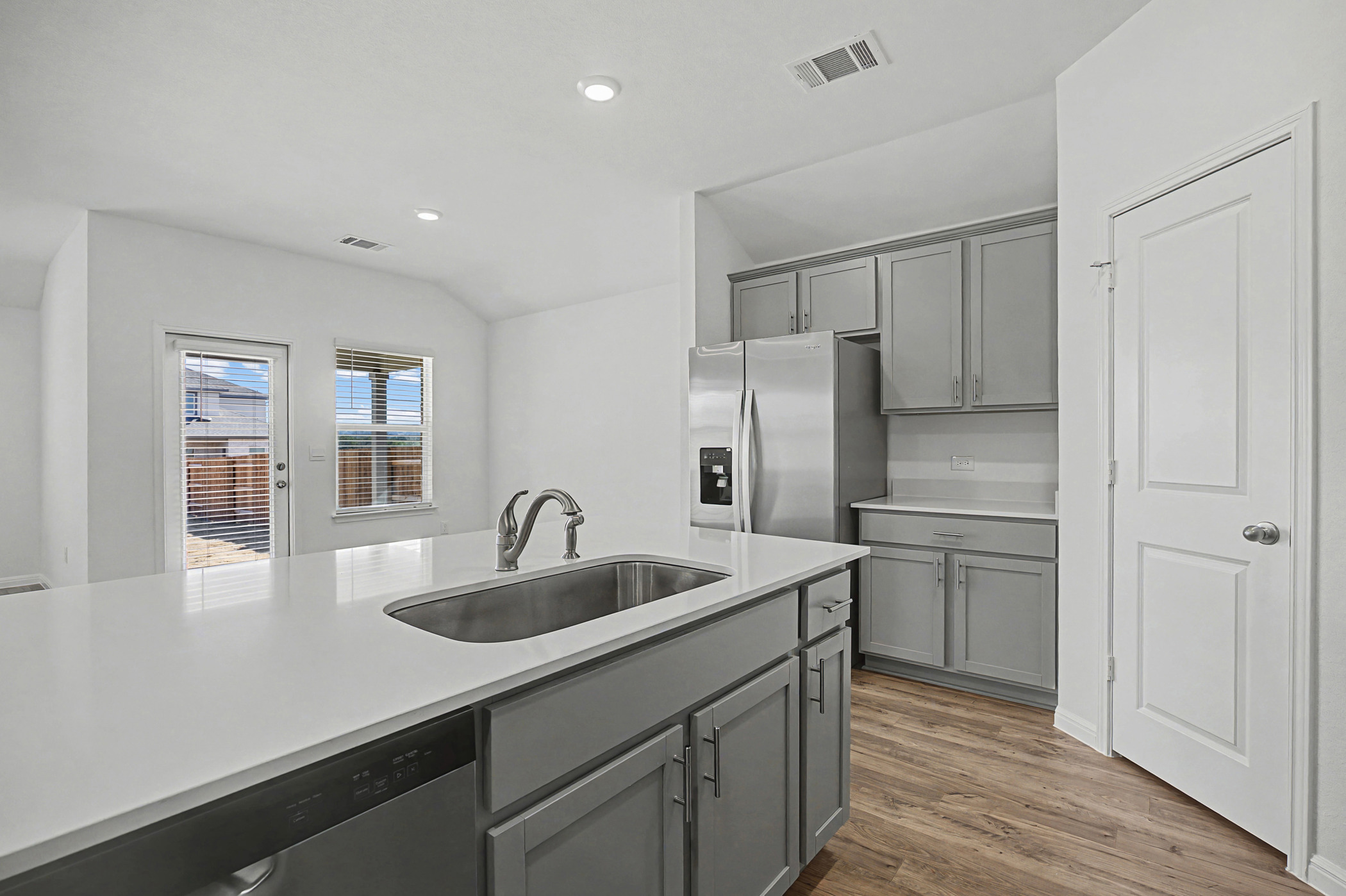 1908 Pogonip Place Leander, TX 78641 - Photo 5 of 21 Kitchen with gray cabinets, stainless steel appliances, dark wood-style flooring, recessed lighting, and lofted ceiling