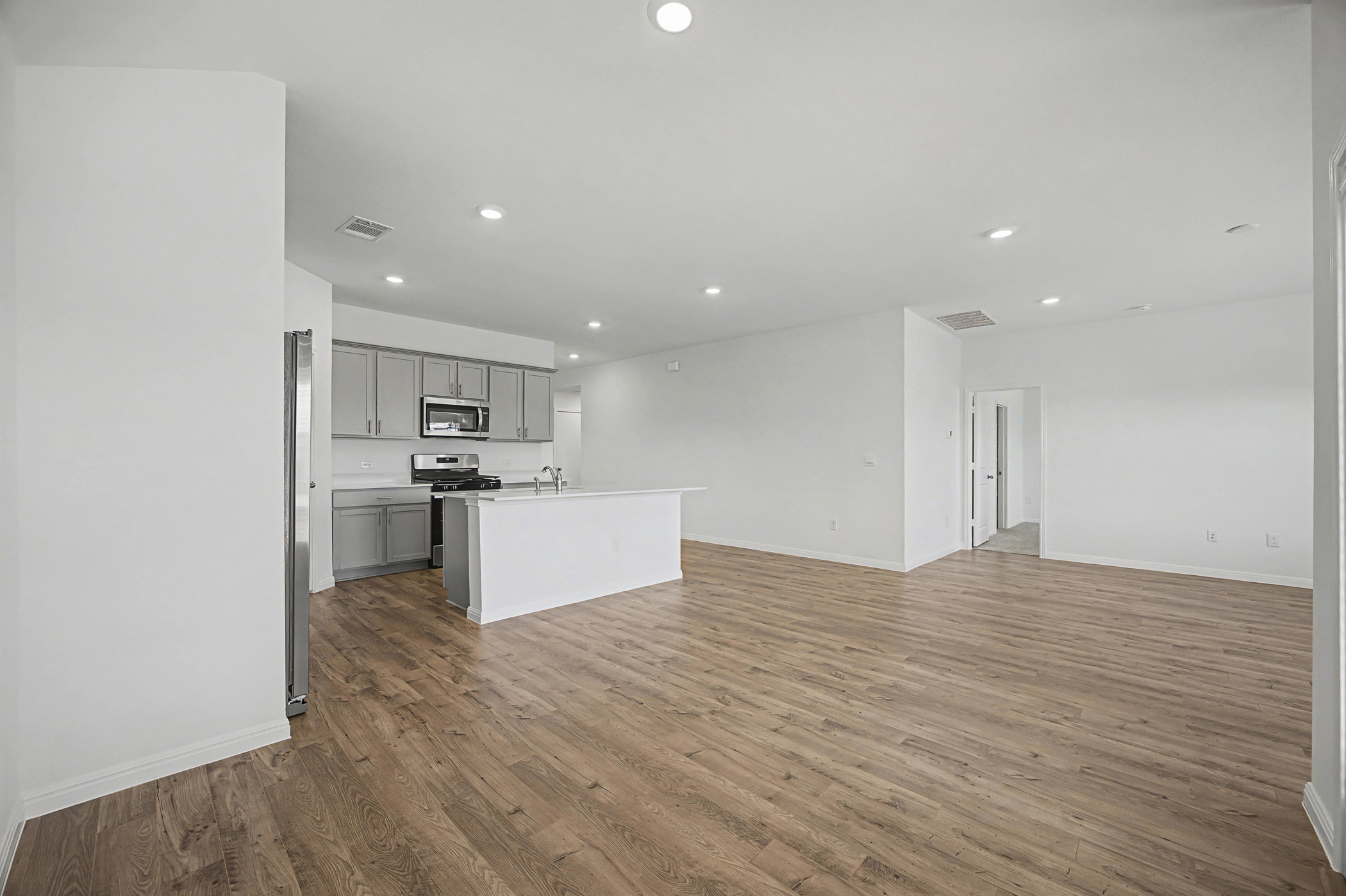1908 Pogonip Place Leander, TX 78641 - Photo 21 of 21 Kitchen with gray cabinetry, open floor plan, dark wood-style floors, recessed lighting, and stainless steel appliances