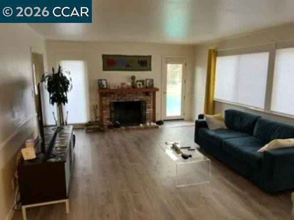 a living room with furniture and a large mirror next to a window