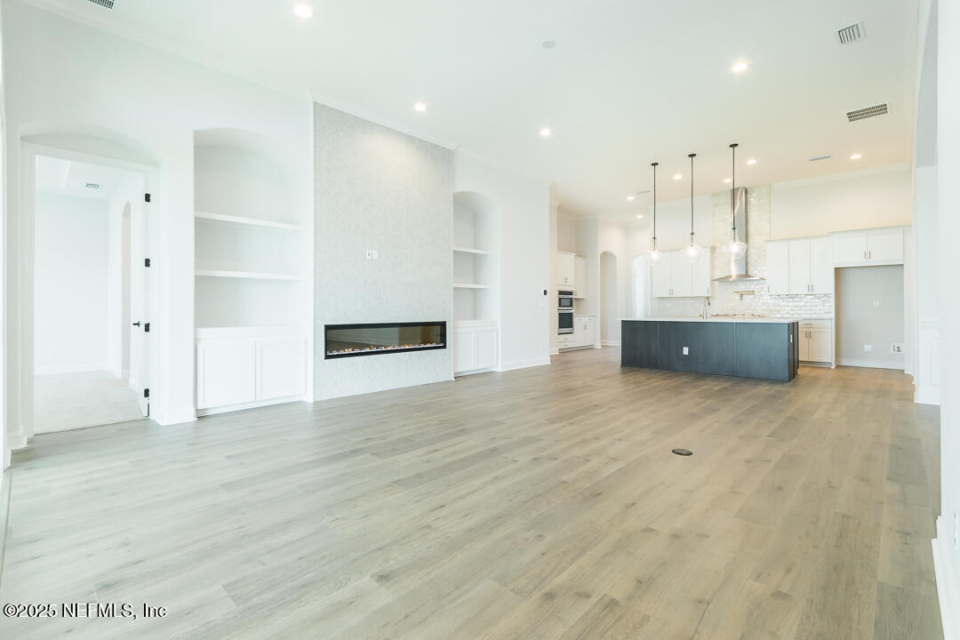 303 Eagle Moon Lake Drive St. Augustine, FL 32092 - Photo 11 of 35 an empty room with wooden floor and windows