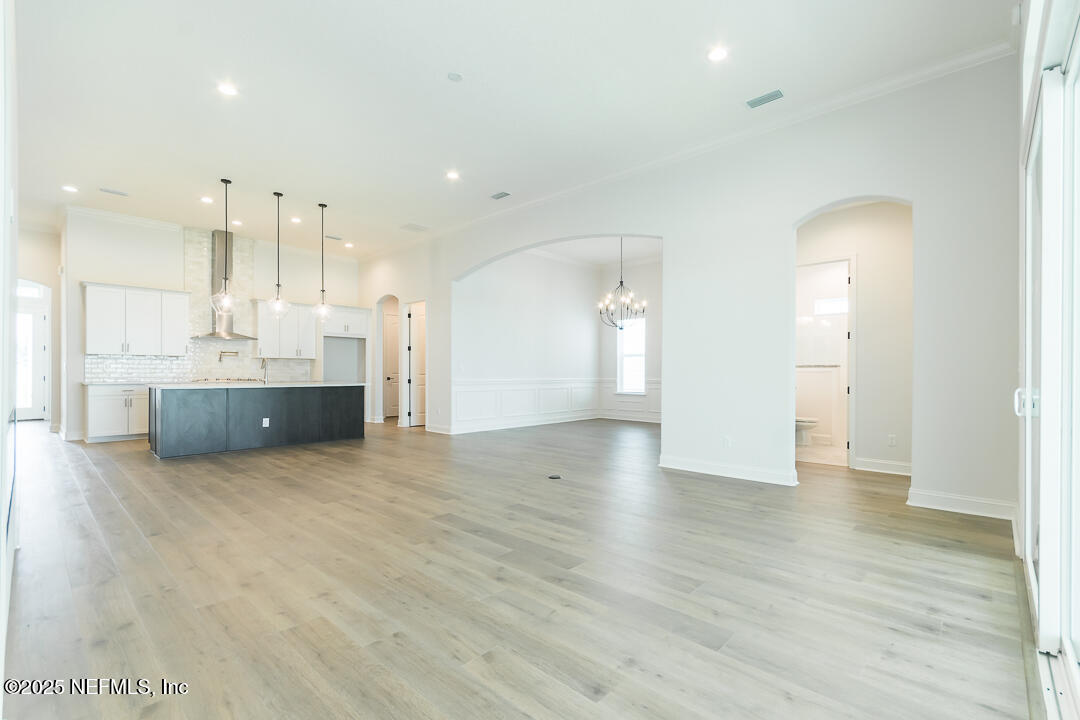 303 Eagle Moon Lake Drive St. Augustine, FL 32092 - Photo 12 of 35 an empty room with wooden floor and windows