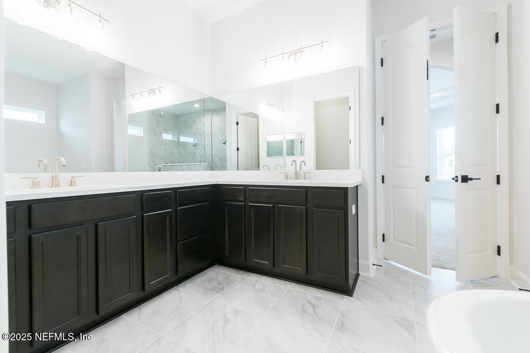 303 Eagle Moon Lake Drive St. Augustine, FL 32092 - Photo 23 of 35 a bathroom with a granite countertop sink mirror and