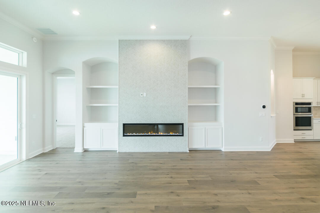 303 Eagle Moon Lake Drive St. Augustine, FL 32092 - Photo 10 of 35 a view of an empty room with wooden floor and kitchen space