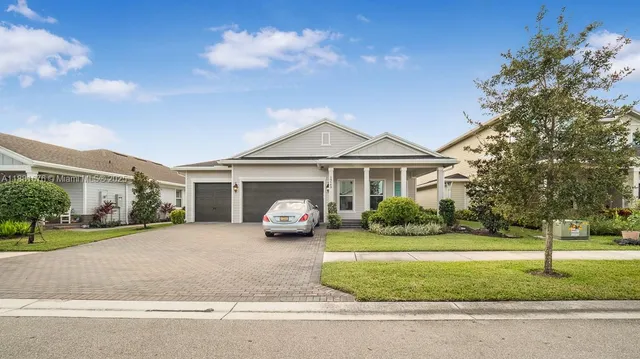 a front view of a house with a garden and plants