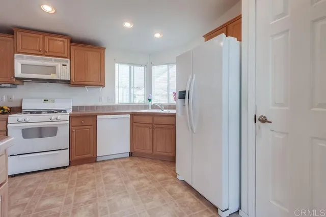 a kitchen with white cabinets and white appliances