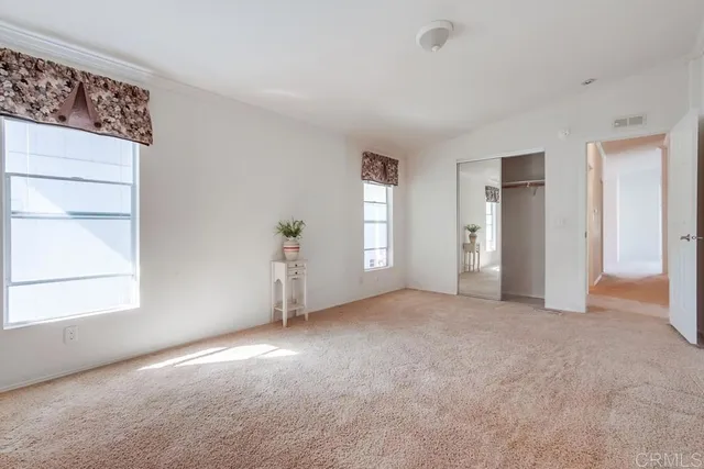 an empty room with windows and painted walls