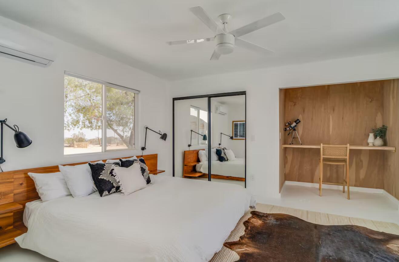 57725 Junipero Trail Yucca Valley, CA 92284 - Photo 10 of 46 a bedroom with a large bed and a chandelier