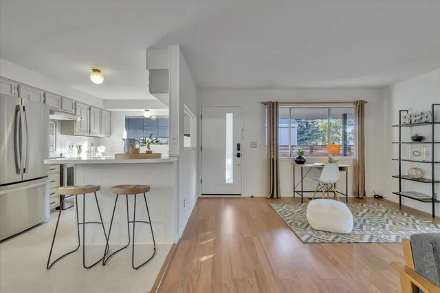 a kitchen with granite countertop a stove a refrigerator and wooden floor