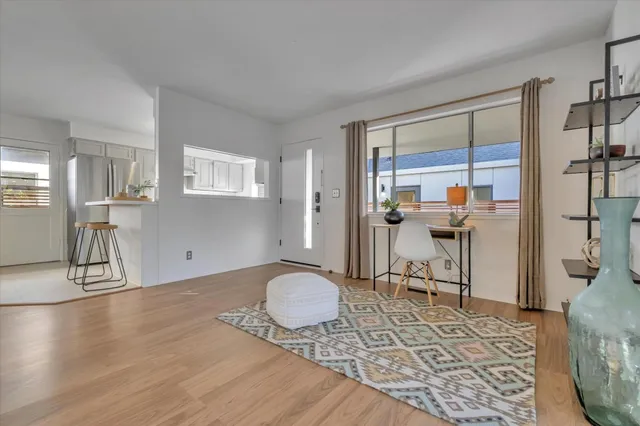 a view of a workspace room with wooden floor and a rug