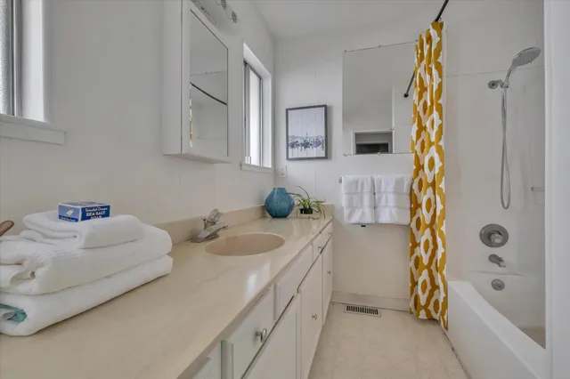 a bathroom with a bathtub sink and mirror