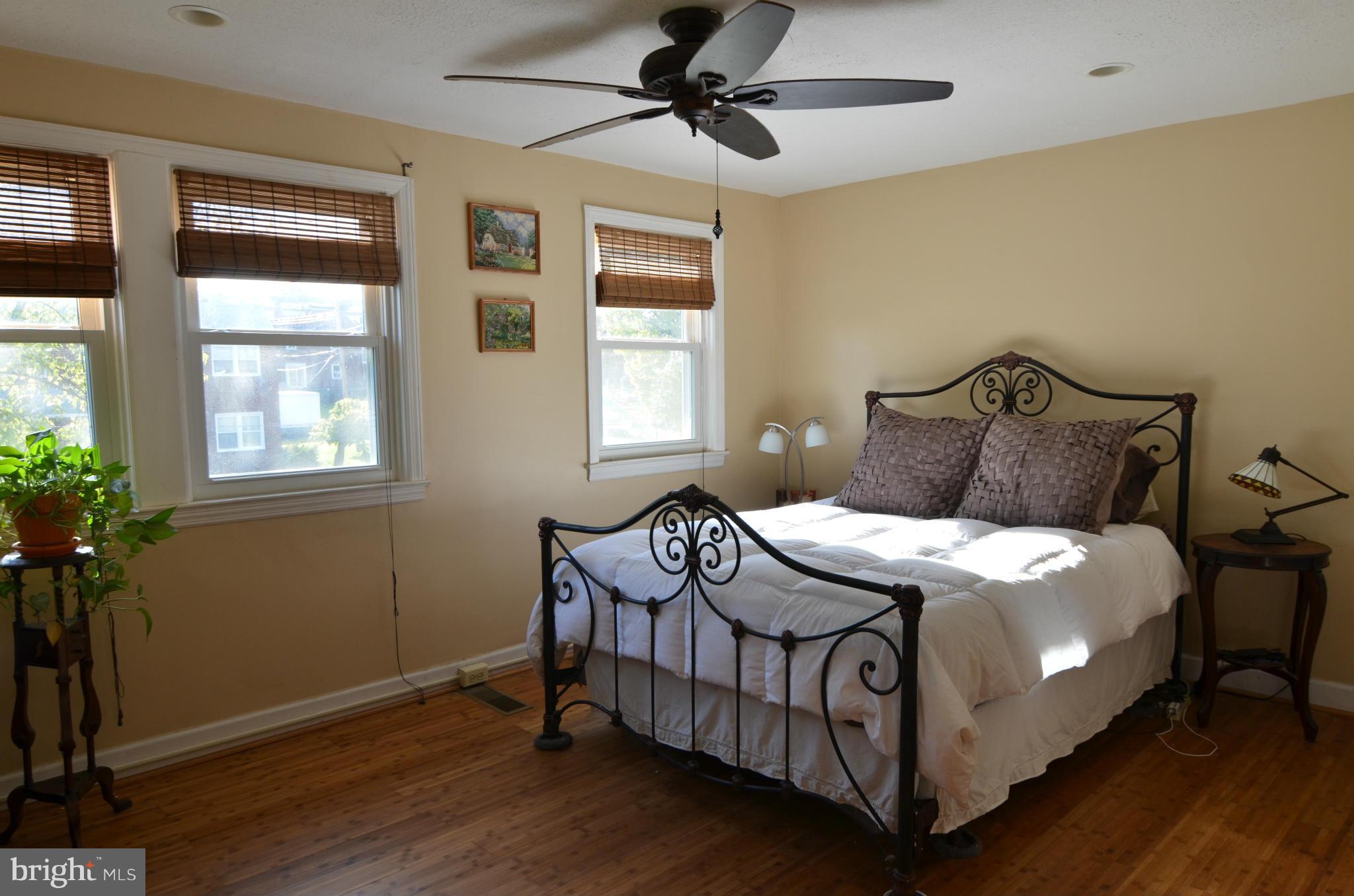 600 Old Riverside Road Baltimore, MD 21225 - Photo 10 of 15 a bedroom with a bed next to a window with potted plants