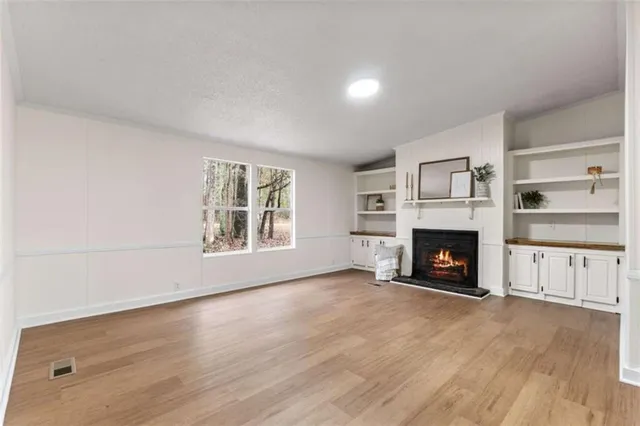 a view of an empty room with a fireplace and a window