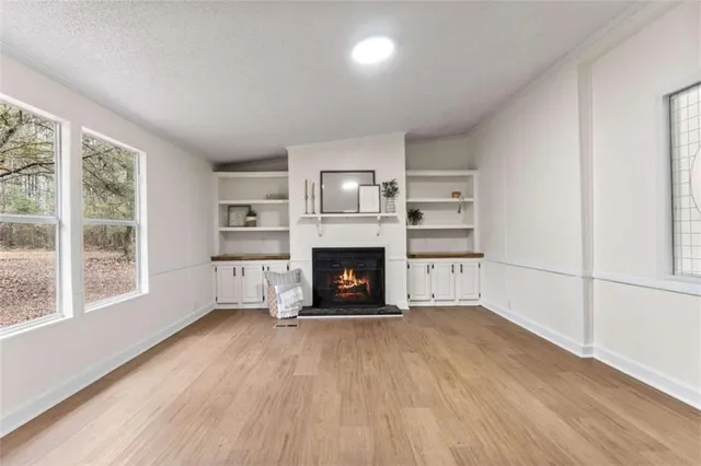 a view of an empty room with a fireplace and a window