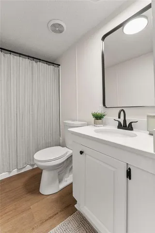 a bathroom with a toilet a sink and mirror