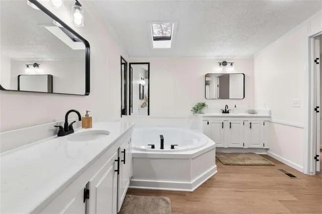 a bathroom with sink bathtub and mirror