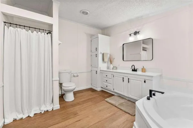 a bathroom with a double vanity sink a mirror and a bathtub