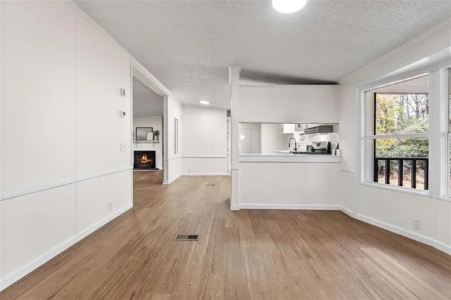 a view of a kitchen with a refrigerator a stove top oven and wooden floor