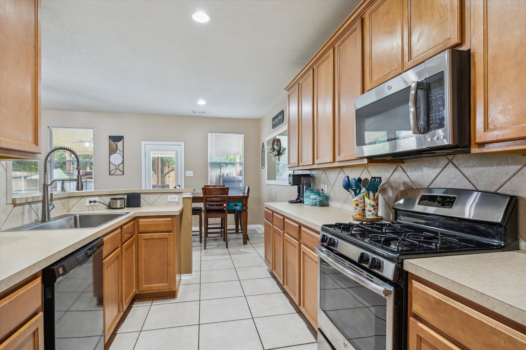 225 Drake Run Lane Dickinson, TX 77539 - Photo 7 of 22 a kitchen with stainless steel appliances a sink stove and cabinets