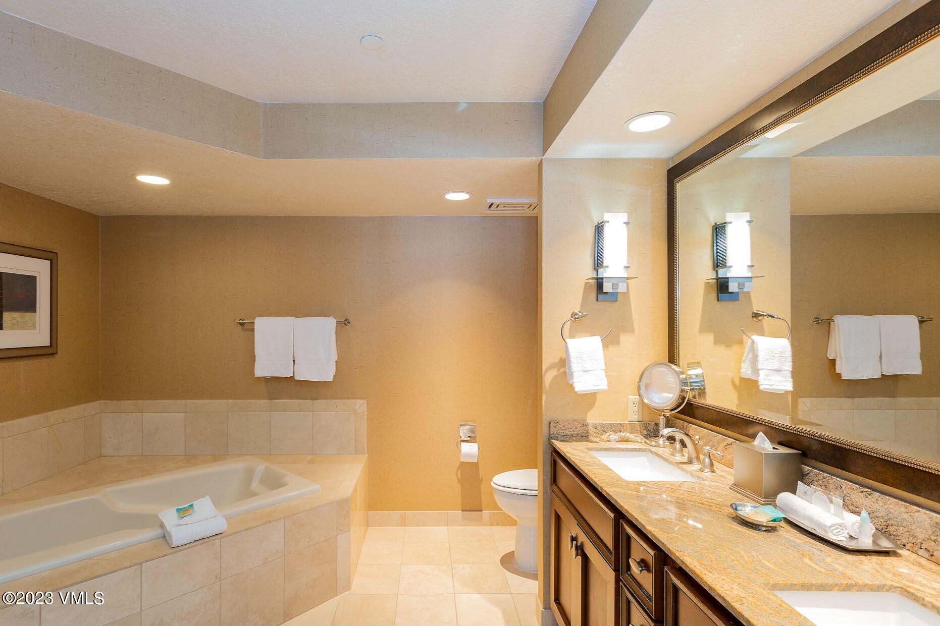 210 Offerson Road, Unit 308 WEEK 49 Beaver Creek, CO 81620 - Photo 21 of 31 a bathroom with a granite countertop sink a bathtub a mirror and vanity