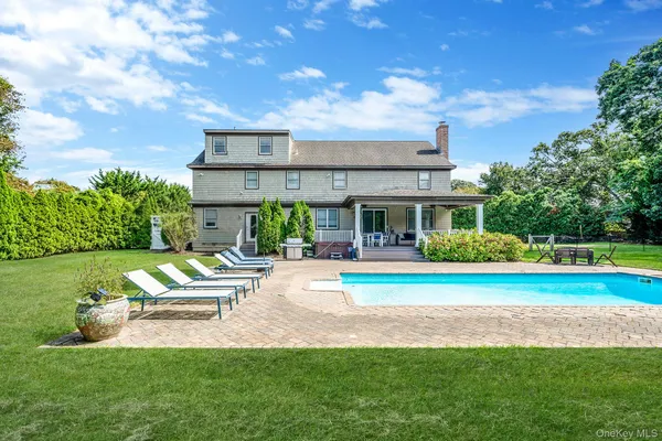 a view of a house with a big yard potted plants and large tree