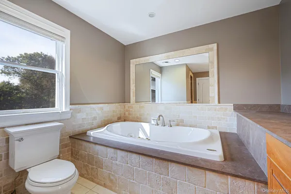a bathroom with a granite countertop sink mirror vanity and toilet