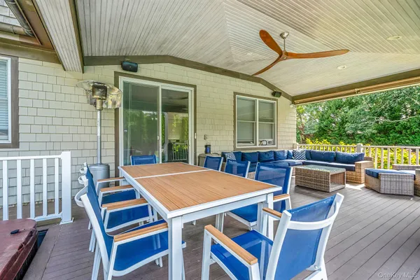 a view of a patio with table and chairs with wooden floor and fence