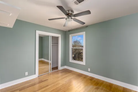 an empty room with windows and fan
