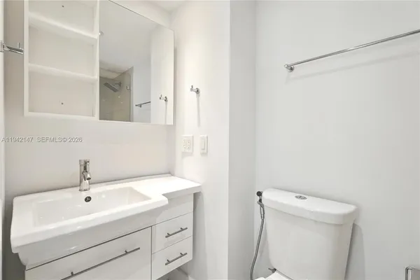 a bathroom with a sink a toilet and a mirror