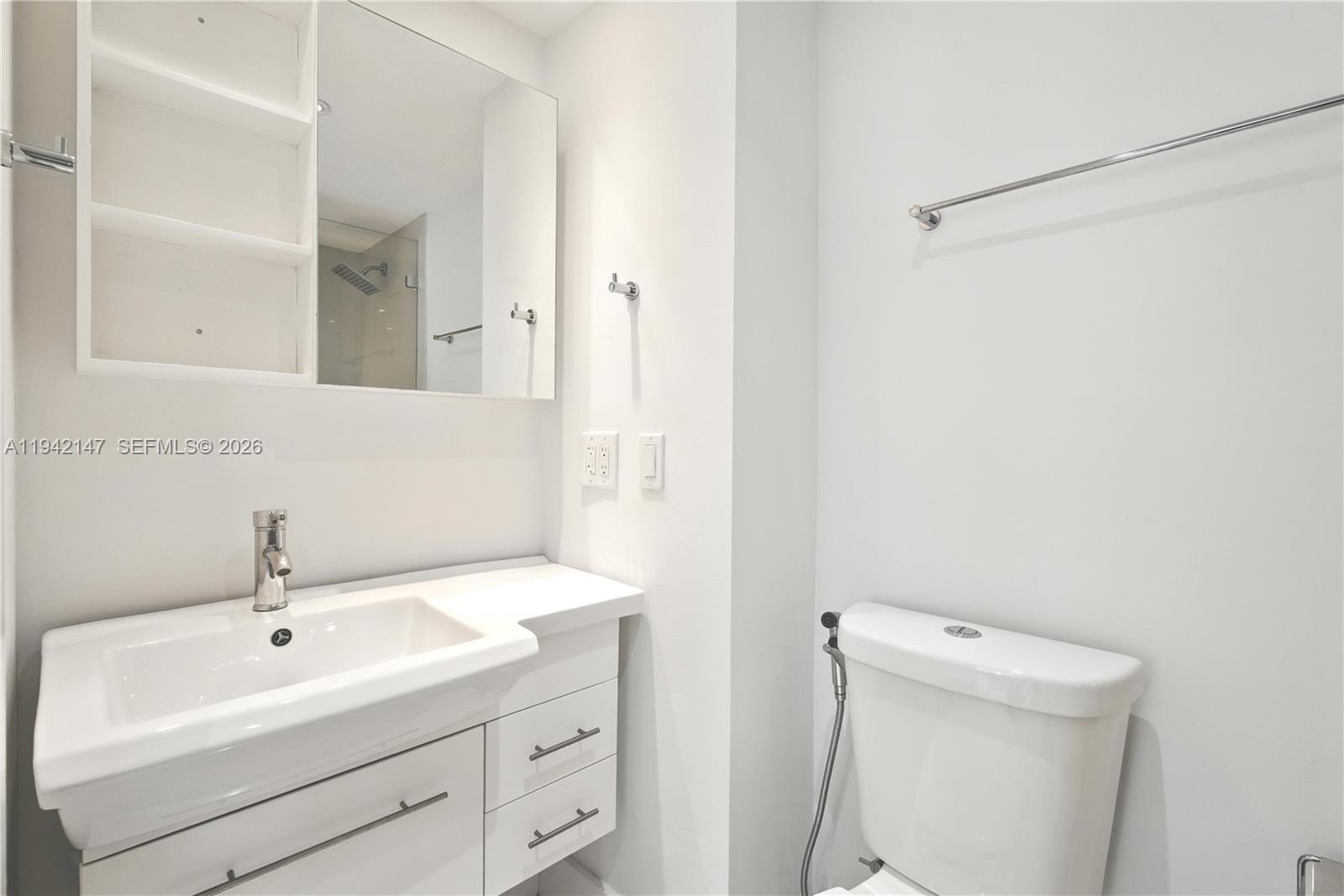 200 Southeast 15th Road, Unit 9I Miami, FL 33129 - Photo 16 of 24 a bathroom with a sink a toilet and a mirror