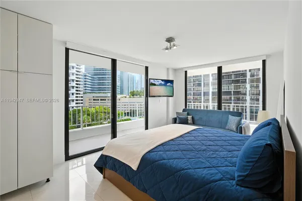 a bedroom with a large bed and a balcony view