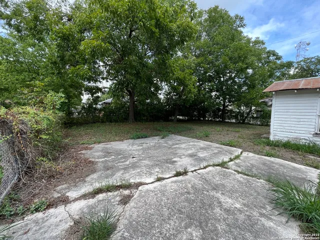 a view of a backyard with large trees