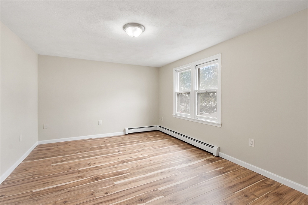 21 Crescent Street, Unit D Lawrence, MA 01841 - Photo 18 of 25 an empty room with wooden floor and windows