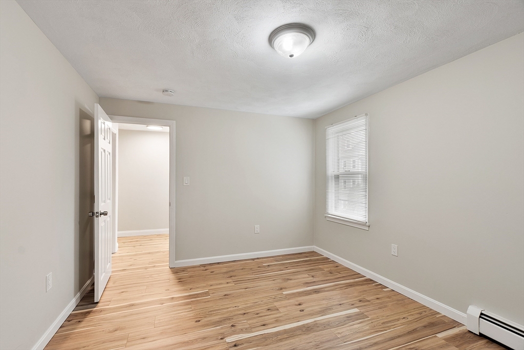 21 Crescent Street, Unit D Lawrence, MA 01841 - Photo 21 of 25 an empty room with wooden floor and windows