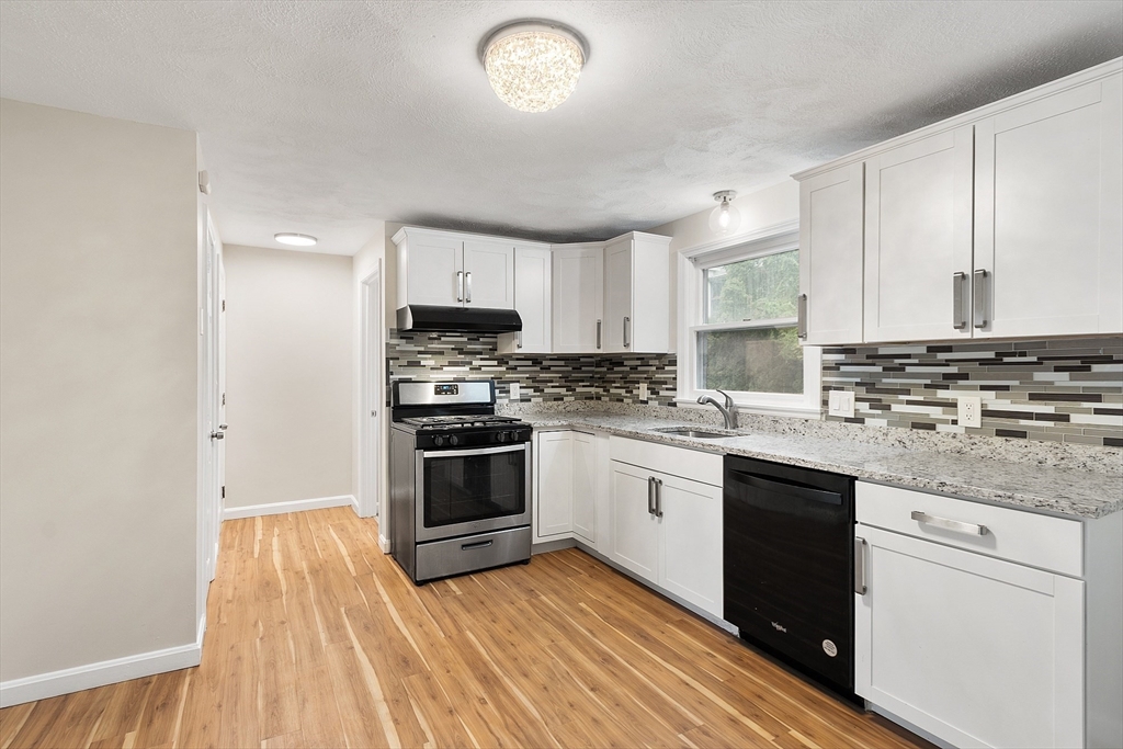 21 Crescent Street, Unit D Lawrence, MA 01841 - Photo 22 of 25 a kitchen with stainless steel appliances granite countertop a stove a sink and a microwave