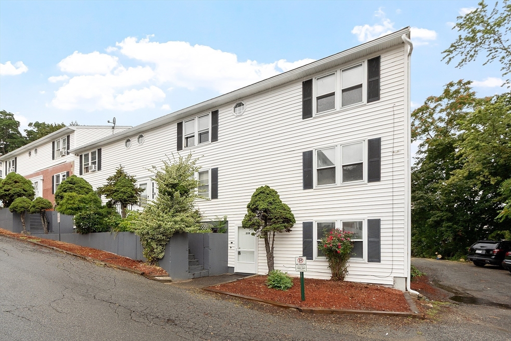 21 Crescent Street, Unit D Lawrence, MA 01841 - Photo 3 of 25 a front view of a house with a yard and garage