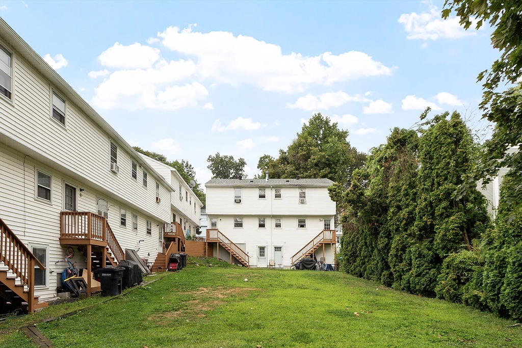 21 Crescent Street, Unit D Lawrence, MA 01841 - Photo 6 of 25 a view of a white house with a big yard and large trees