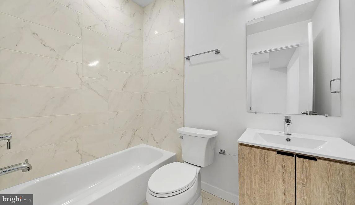 300 Budd Street, Unit B2 Philadelphia, PA 19104 - Photo 9 of 23 a white toilet sitting next to a bathroom sink and vanity