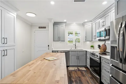 a kitchen with a refrigerator a sink and cabinets